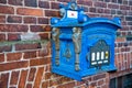 Post box blue color on red brick wall background Royalty Free Stock Photo