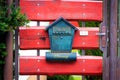 Post box on red wooden gate