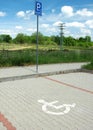 Post with disabled parking space and sign in front of parking bay in car park Royalty Free Stock Photo