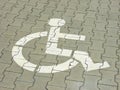 Post with disabled parking space and sign in front of parking bay in car park Royalty Free Stock Photo