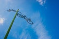 Post with the figure of some bicycles indicating the road, with blue sky and clouds in the background Royalty Free Stock Photo