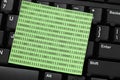 Post-it note with binary code on keyboard Royalty Free Stock Photo