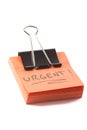 Post-it note with clip and message urgent on white background