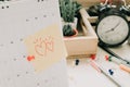 post note paper with couple heart sticky on calendar and business equipment clock, plant background. image for copy Royalty Free Stock Photo