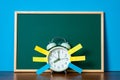 Post it note paper sticky and vintage alarm clock and blank green chalkboard on table with copy space for add text notice Royalty Free Stock Photo