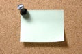 Post-it note with pushpin on corkboard