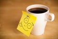 Post-it note with smiley face sticked on a cup Royalty Free Stock Photo