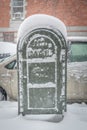 Post office mail box covered in snow on a cold snowy winter day in New York City