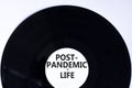 Post-pandemic life symbol. Concept words Post-pandemic life on retro black vinyl disc. Beautiful white background, copy space.