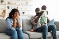 Tired African American mom crying, dad playing with kid Royalty Free Stock Photo