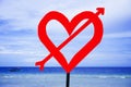 post signal with red love heart and arrow at beach on a blue sea and sky background in Valentines day and romance concept