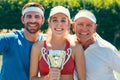 Post victory picture is necessary. Cropped portrait of a group of sportspeople standing together and holding a trophy