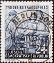 A postage stamp from Germany, GDR showing a country deliverer with bicycle hands over mail. Text: Stam Royalty Free Stock Photo