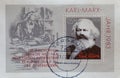 a postage stamp from Germany, GDR showing a portrait of Karl Marx on the 100th anniversary of his death. On a postal stamp pad