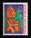 Postage stamp Indonesia West Irian 1970. Seated man wooden carved statue Royalty Free Stock Photo