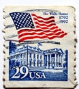 A postage stamp printed in the United States of America shows the waving American flag over the White House circa 1992 Royalty Free Stock Photo