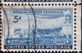 a postage stamp printed in the US showing a Swedish pioneerÃ¢â¬â¢s covered wagon traveling westward. Swedish Pioneer