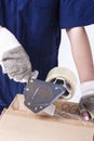 Postal and Moving. Closeup of Female Hands Packing Cardboard Box Indoors Unsing A Tape-Machine Royalty Free Stock Photo