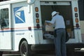 Postal worker at the back of truck with package