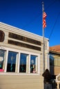 A postal worker raises the Flag outside of the post office