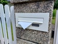 postbox on white fence. Letters in mailbox