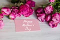 Postcard with bouquet of small pink roses on white rustic wooden background. Happy mother`s day text sign. Greeting card with Royalty Free Stock Photo