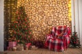 Postcard from a Christmas tree with an armchair and copy space. Details of a decorated interior with gifts with a frame for text. Royalty Free Stock Photo