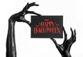 Postcard and Happy Halloween theme: black hand of death holding a paper card with the words Happy Halloween on a white isolated ba