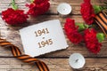 Postcard may 9 - red carnations Ribbon George Old photos on a wooden background. Symbol of victory in the great Patriotic war Royalty Free Stock Photo