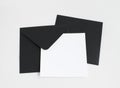 Two black envelopes with white paper on grey background. Postcard template. Royalty Free Stock Photo