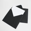Two black envelopes with white paper on grey background. Postcard template. Royalty Free Stock Photo