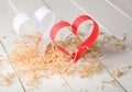 Postcard to Valentine's Day. White and red heart made of paper strips. Decorative curly wood shavings