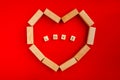 Postcard to Valentine's Day. Red background with a natural wood heart and the word love inside the heart Royalty Free Stock Photo