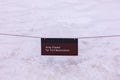 A posted sign `Area closed for turf restoration` above the lawn covered with deep snow