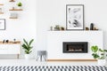 Poster above black fireplace in white living room interior with Royalty Free Stock Photo