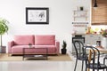 Poster above pink couch in white apartment interior with black c Royalty Free Stock Photo