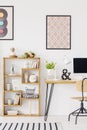 Poster above wooden desk with plant and desktop computer in home Royalty Free Stock Photo