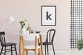 Poster on pastel pink wall of sophisticated dining room interior with round table Royalty Free Stock Photo