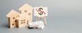 Poster with down arrow and wooden houses. The concept of falling real estate market. Reduced interest in the mortgage. A decline Royalty Free Stock Photo