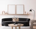 Poster frame mockup in modern living room, black minimal sofa on white wall background Royalty Free Stock Photo