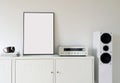 Poster Frame Mockup in white modern interior. Modern audio stereo system with white speakers on bureau in modern interior. Royalty Free Stock Photo