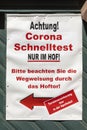 Poster with german description of Corona Test. Text in english: attention Corona Test at tge court yard. please follow the arrow