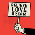 Poster in hand, business concept with text Believe Love Dream