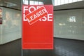 Poster of `For Lease` with a `Leased` sign on top in front of a vacant shop. Concept of rental commercial property or retail s Royalty Free Stock Photo