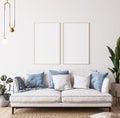 Poster mockup in bright modern room, white sofa with blue cushions and green plants on minimal background Royalty Free Stock Photo
