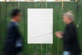 Poster mockup on a green wooden fence. People pass by the poster