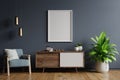 Poster mockup with vertical frames on empty dark wall in living room interior with blue velvet armchair Royalty Free Stock Photo