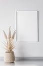 Poster mockup with vertical white frame on modern wall with trendy pampas plant