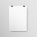 Poster A4 mockup. White vertical empty paper with clips. Realistic template hanging on a light wall. White sheet with Royalty Free Stock Photo