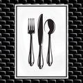 Poster with a spoon, fork and knife on white background and on black brick wall Royalty Free Stock Photo